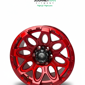 Journeyman Fitment metallic red 8-spoke off-road wheel with oval cutouts and rugged texture.